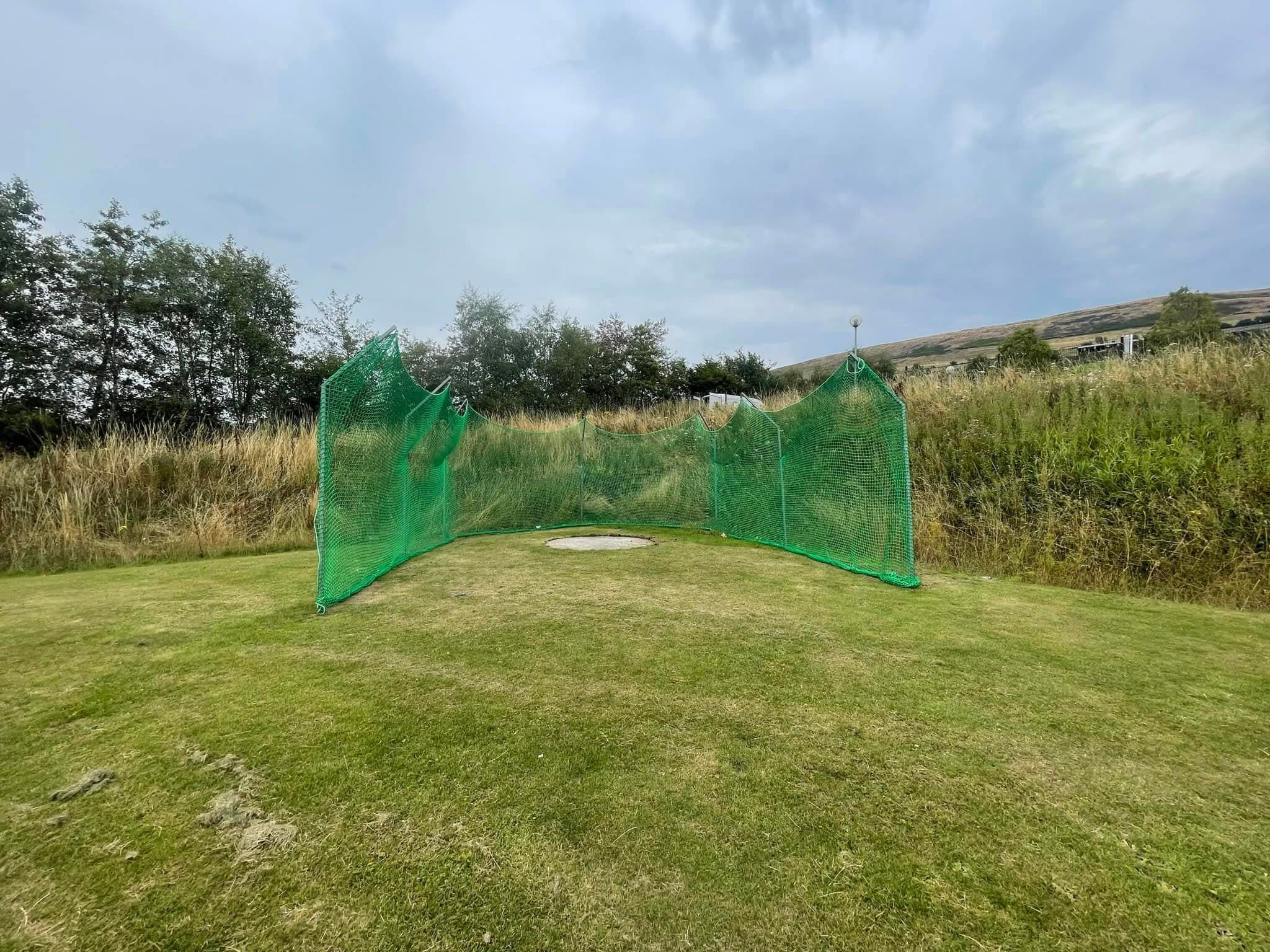 Cricket practice nets installed on a grass ground