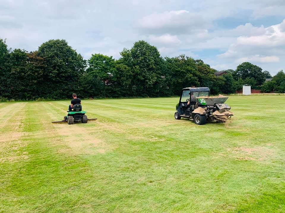 Two JG Groundcare ride-on mowers and a utility vehicle cutting a large grass field