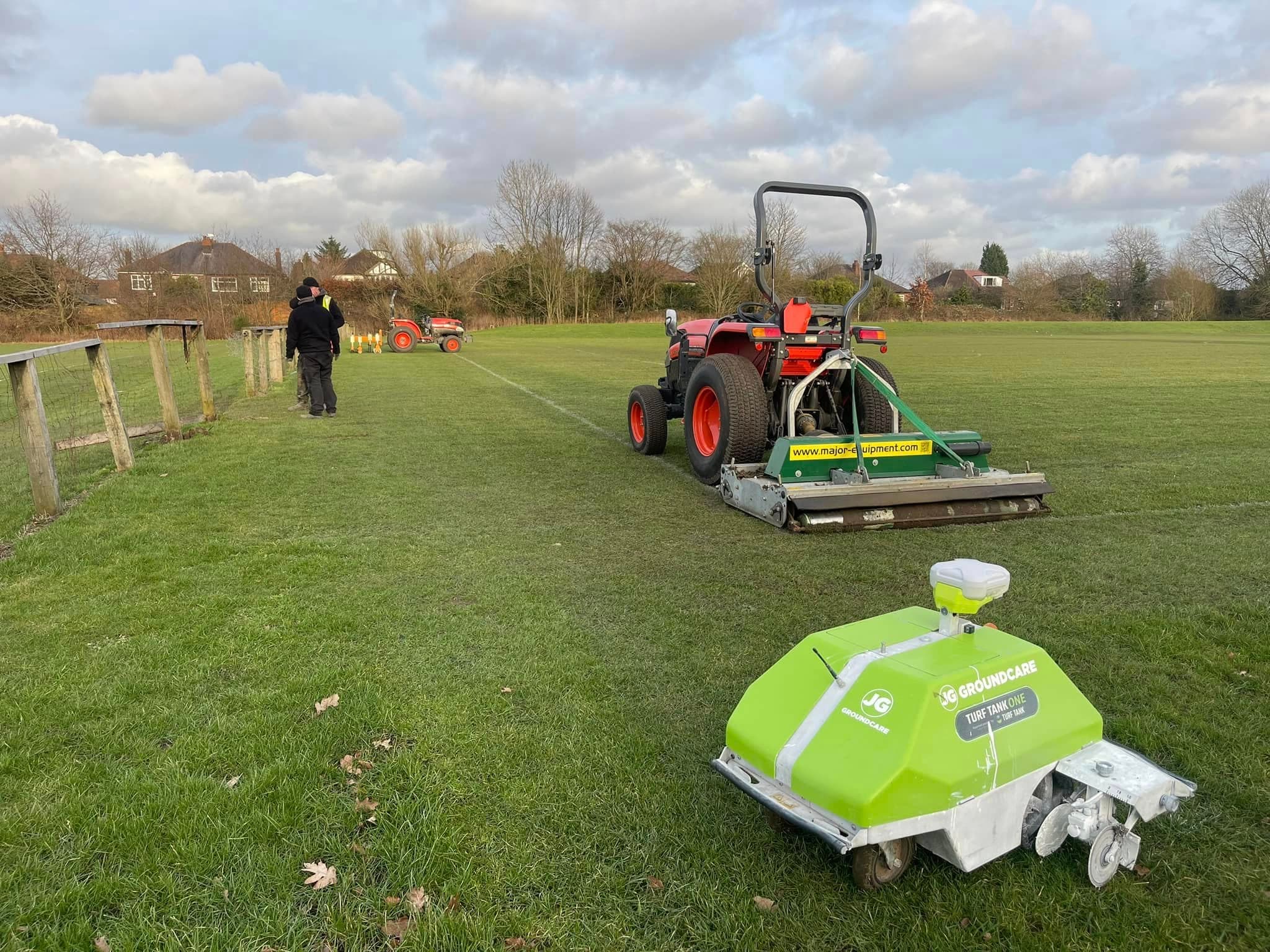 JG robot line marker on a freshly marked pitch with a tractor and operative behind