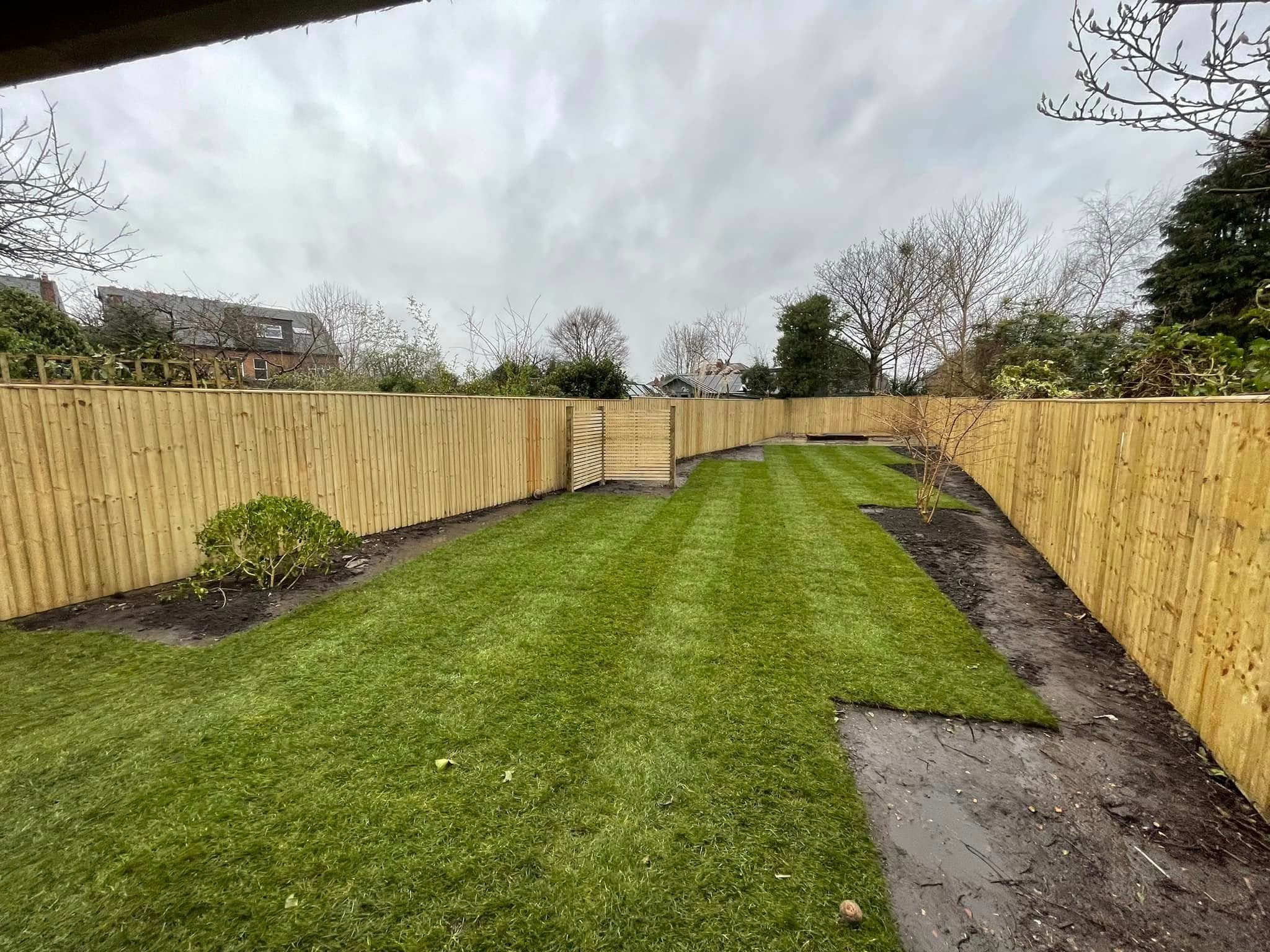 New close-board timber fencing behind a striped lawn
